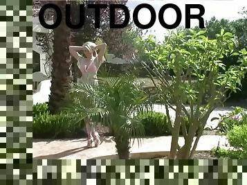 Gorgeous blonde plays with her pink pussy outdoors
