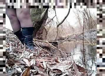 Curvy MILF pissing on the riverside