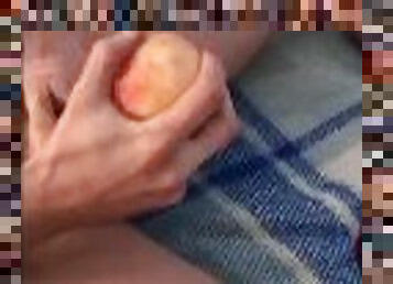 boy jerks off his dick with a peach