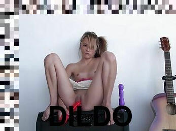 Teen sits on an amp and toys her tight pussy