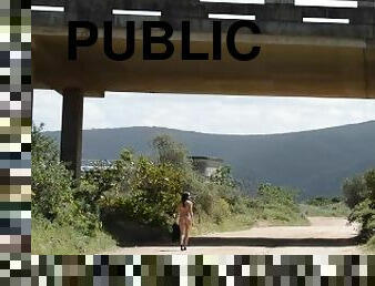 Walking Naked on open road under a bridge