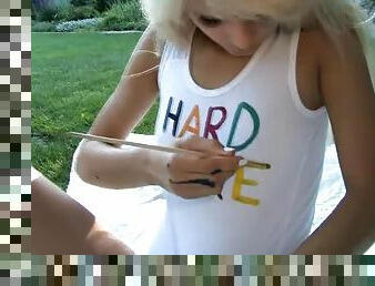 Lolly paints her body outdoors