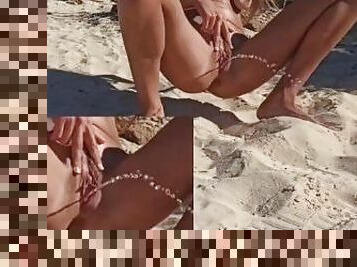 young woman on the beach watched by everyone takes a long and golden piss completely naked