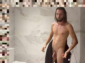 Un hombre desnudo y solo en el bao hace su ducha erotica